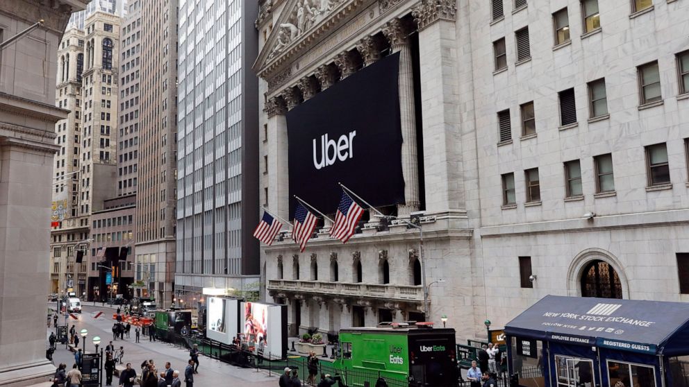 FILE - In this May 10, 2019, file photo, an Uber banner hangs on the facade of the New York Stock Exchange. Uber is continuing to bleed money even as it posts dramatic revenue growth. In its first financial release since its lackluster IPO, Uber repo