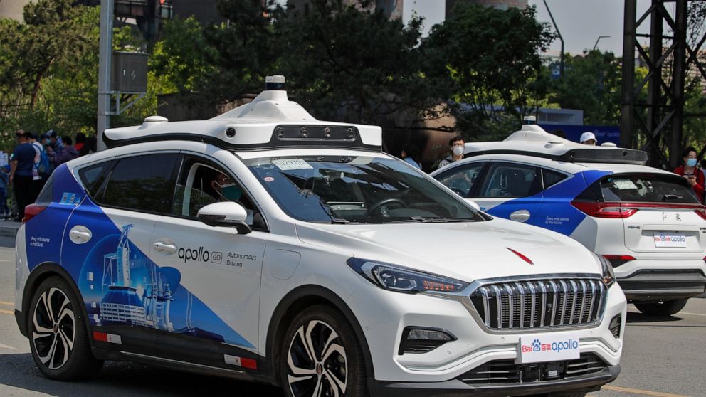 Baidu Apollo Robotaxis move on a street at the Shougang Park in Beijing, Sunday, May 2, 2021. Chinese tech giant Baidu rolled out its paid driverless taxi service on Sunday, making it the first company that commercialized autonomous driving operation