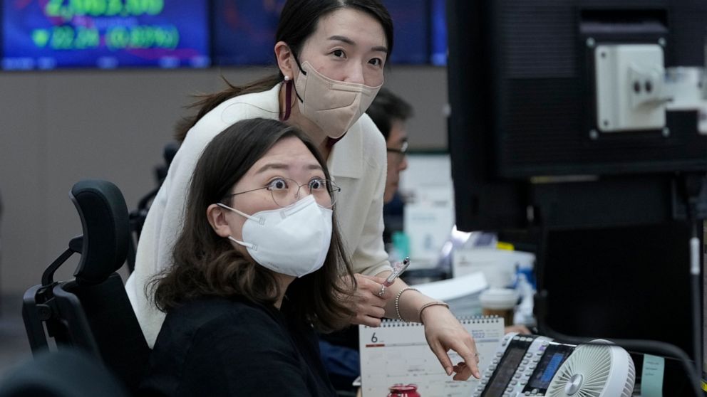Currency traders watch monitors at the foreign exchange dealing room of the KEB Hana Bank headquarters in Seoul, South Korea, Thursday, June 2, 2022. Asian shares declined Thursday, echoing a retreat on Wall Street as investors fretted about higher i