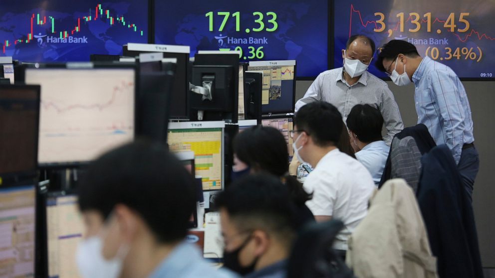 Currency traders wearing face masks work at the foreign exchange dealing room of the KEB Hana Bank headquarters in Seoul, South Korea, Tuesday, April 6, 2021. Asian shares were mixed Tuesday after a Wall Street rally that reflected some optimism abou