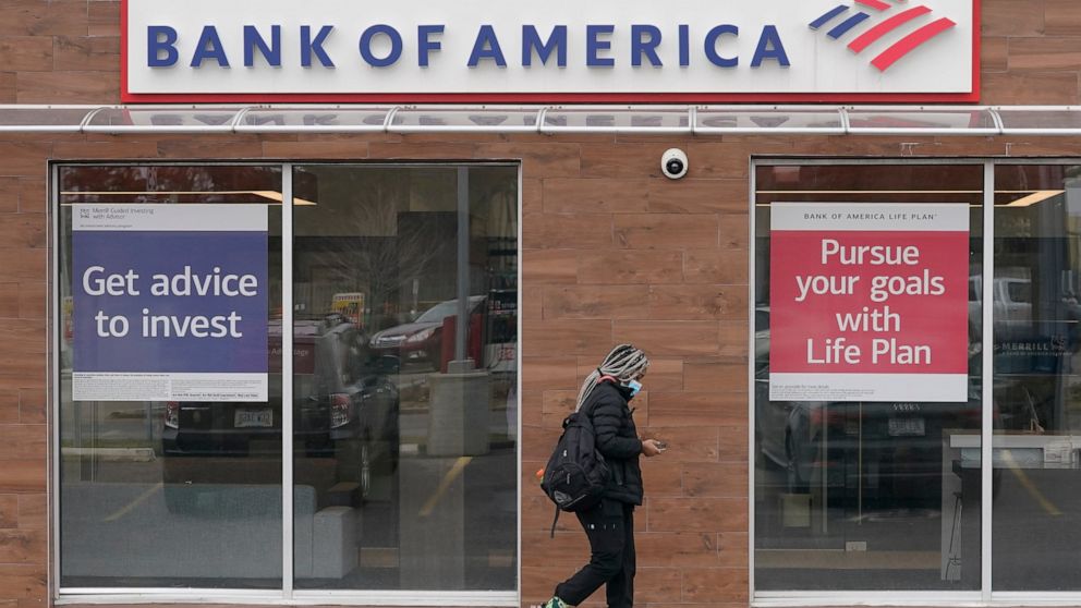A woman walks past a Bank of America branch, Friday, Jan. 14, 2022, in Woodmere Village, Ohio. Bank of America posted a 12% decline in first-quarter profits from a year earlier, a decline that was much less than the ones its rivals had reported the p