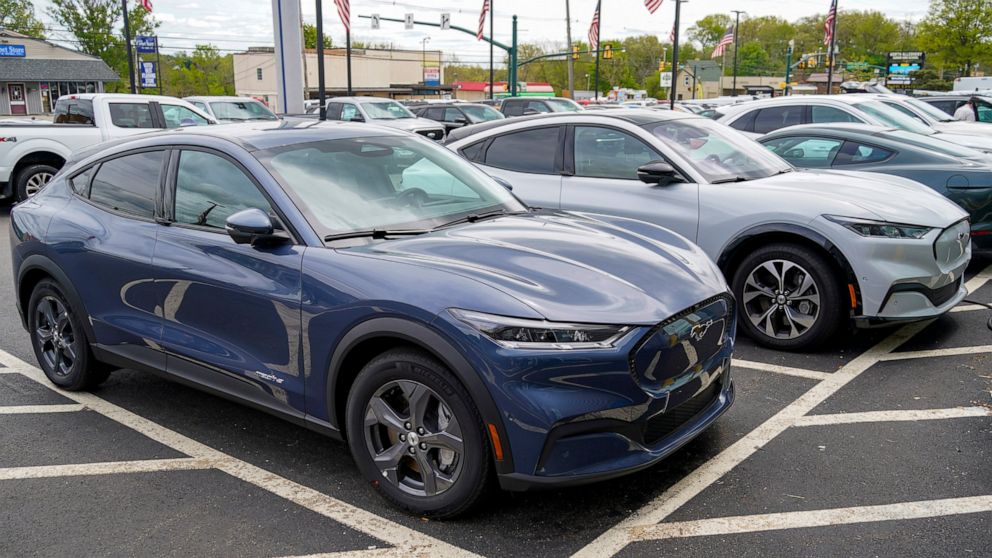 FILE - A pair of 2021 Ford Mustang Mach E are displayed for sale at a Ford dealer on Thursday, May 6, 2021, in Wexford, Pa. U.S. new vehicle sales rebounded slightly last year from 2020′s dismal numbers, but forecasters expect them to be more than 2 