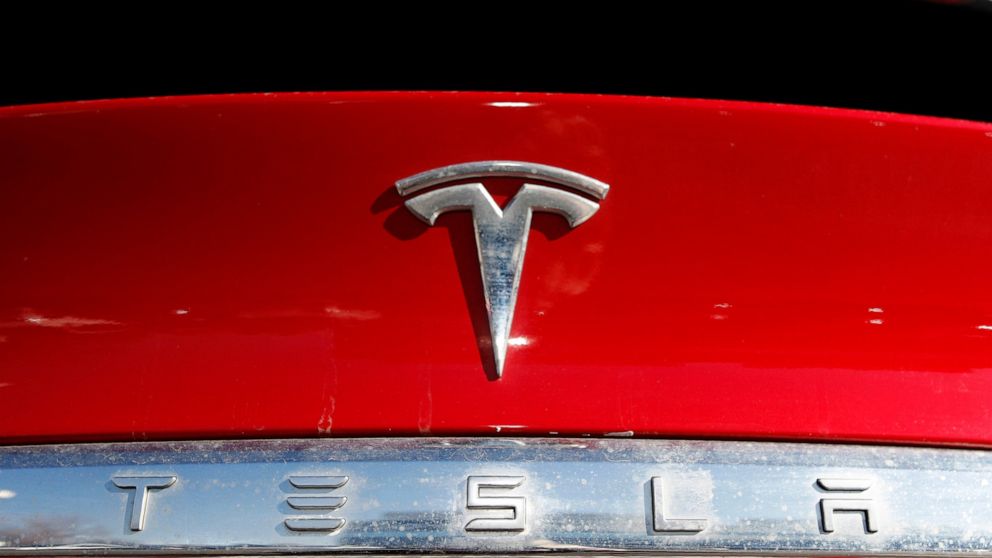 FILE - In this Feb. 2, 2020, file photo, the company logo appears on an unsold 2020 Model X at a Tesla dealership in Littleton, Colo. Tesla reported Wednesday, April 20, 2022, that its first-quarter net earnings were over seven times greater than a y