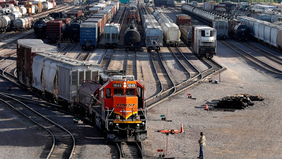 FILE- A BNSF rail terminal worker monitors the departure of a freight train, on June 15, 2021, in Galesburg, Ill. BNSF railroad is tweaking its strict new attendance policy, but the unions that have challenged the rules that took effect in February s