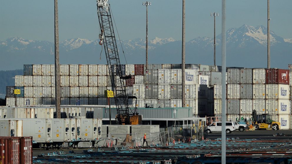 A worker walks near truck trailers and cargo containers, Friday, May 10, 2019, at the Port of Tacoma in Tacoma, Wash. U.S. and Chinese negotiators resumed trade talks Friday under increasing pressure after President Donald Trump raised tariffs on $20