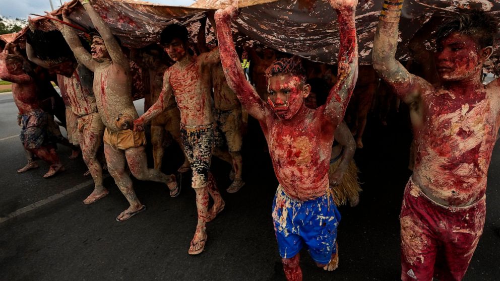 FILE - Indigenous people painted with red ink representing spilled Indigenous blood and clay representing gold, protest against the increase of mining activities that are encroaching on their land, in front of the Ministry of Mines and Energy, in Bra