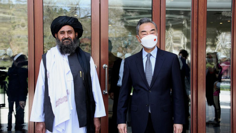 FILE - In this photo released by Xinhua News Agency, Chinese Foreign Minister Wang Yi, right, stands next to Mullah Abdul Ghani Baradar, acting deputy prime minister of the Afghan Taliban's caretaker government, in Kabul, Afghanistan, Thursday, March
