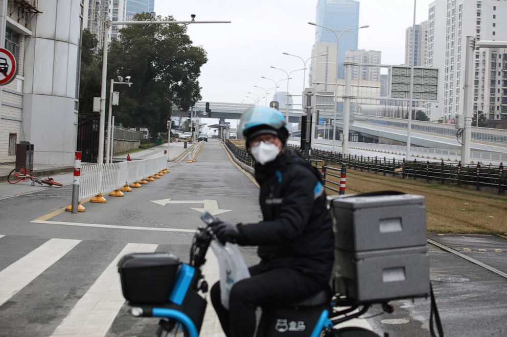 PHOTO: A delivery worker for Alibaba's Hema Fresh chain rides his electric bicycle on a nearly empty road following an outbreak of the novel coronavirus in Wuhan, China, Feb. 7, 2020