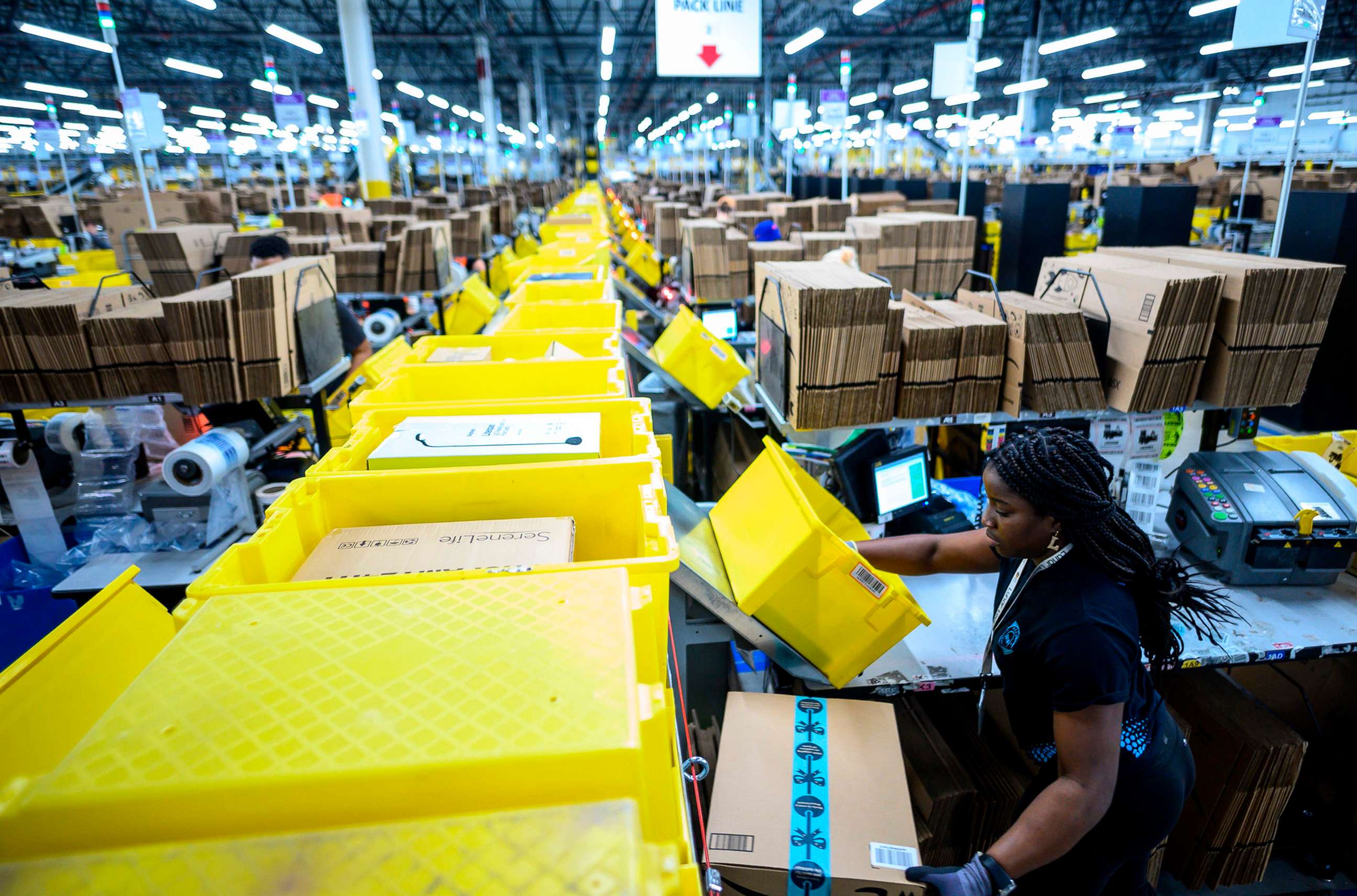 PHOTO: In this file photo taken on February 5, 2019 a woman works at a packing station at the 855,000-square-foot Amazon fulfillment center in Staten Island, New York.
