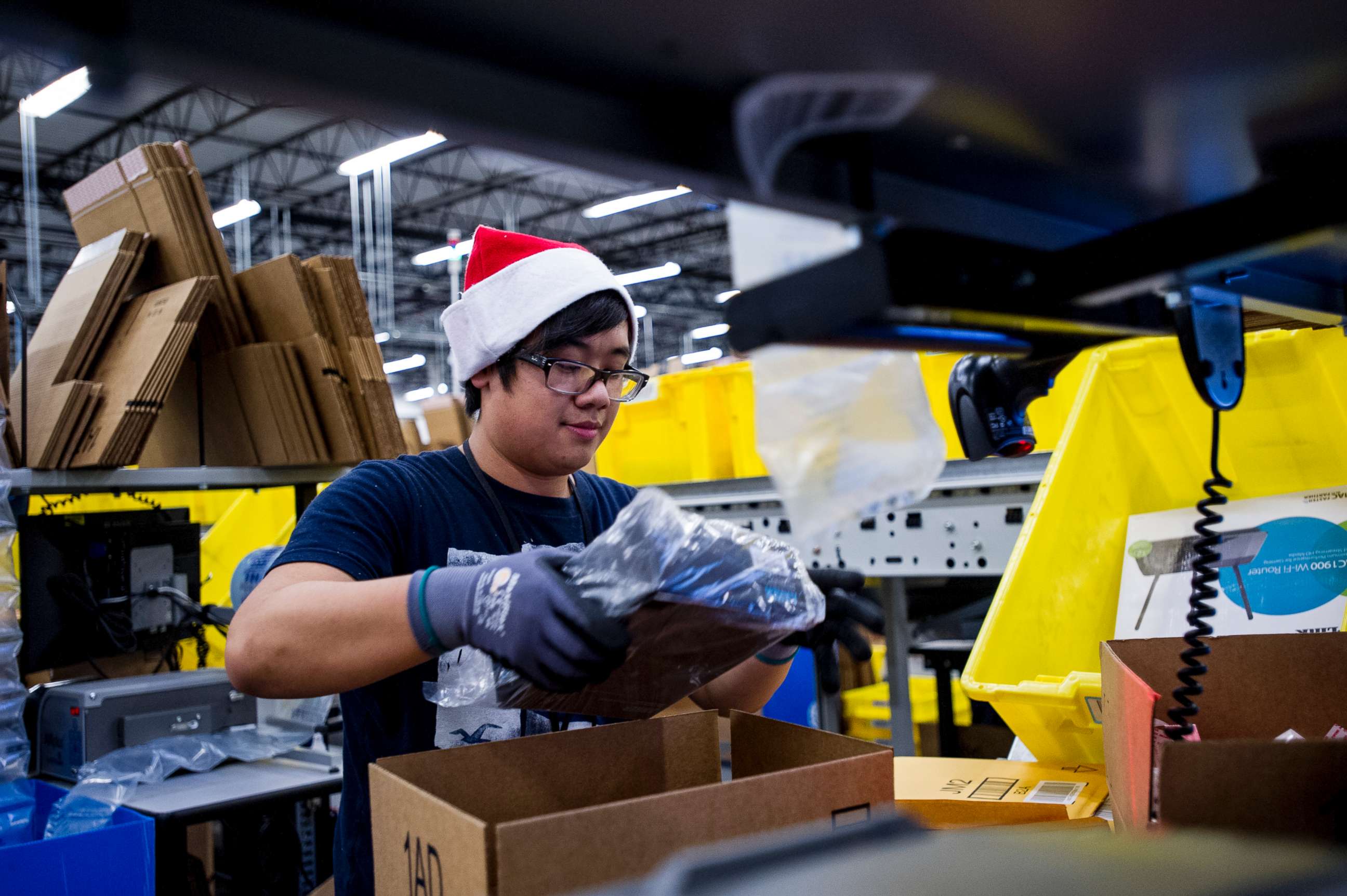PHOTO: An Amazon.com Inc. employee loads merchandise into a box at the company's fulfillment center ahead of Cyber Monday in Tracy, Calif., Nov. 30, 2014.