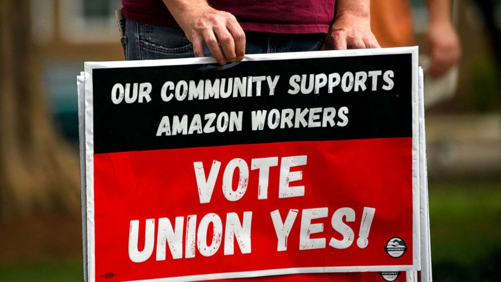 PHOTO: A person holds "Vote Union Yes!" signs during a protest in solidarity with the unionization of Amazon.com fulfillment center workers at Kelly Ingram Park on March 27, 2021 in Birmingham, Ala.