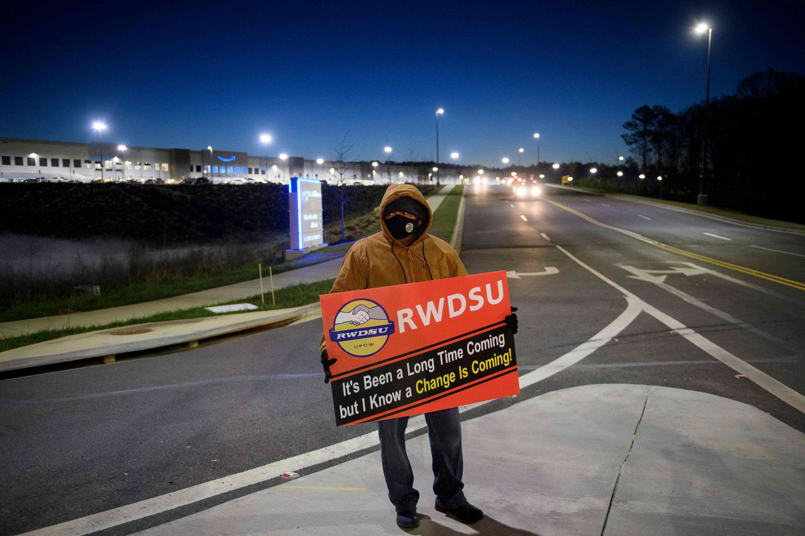 PHOTO: A union supporter stands before sunrise outside the Amazon BHM1 fulfillment center, March 29, 2021, in Bessemer, Ala.
