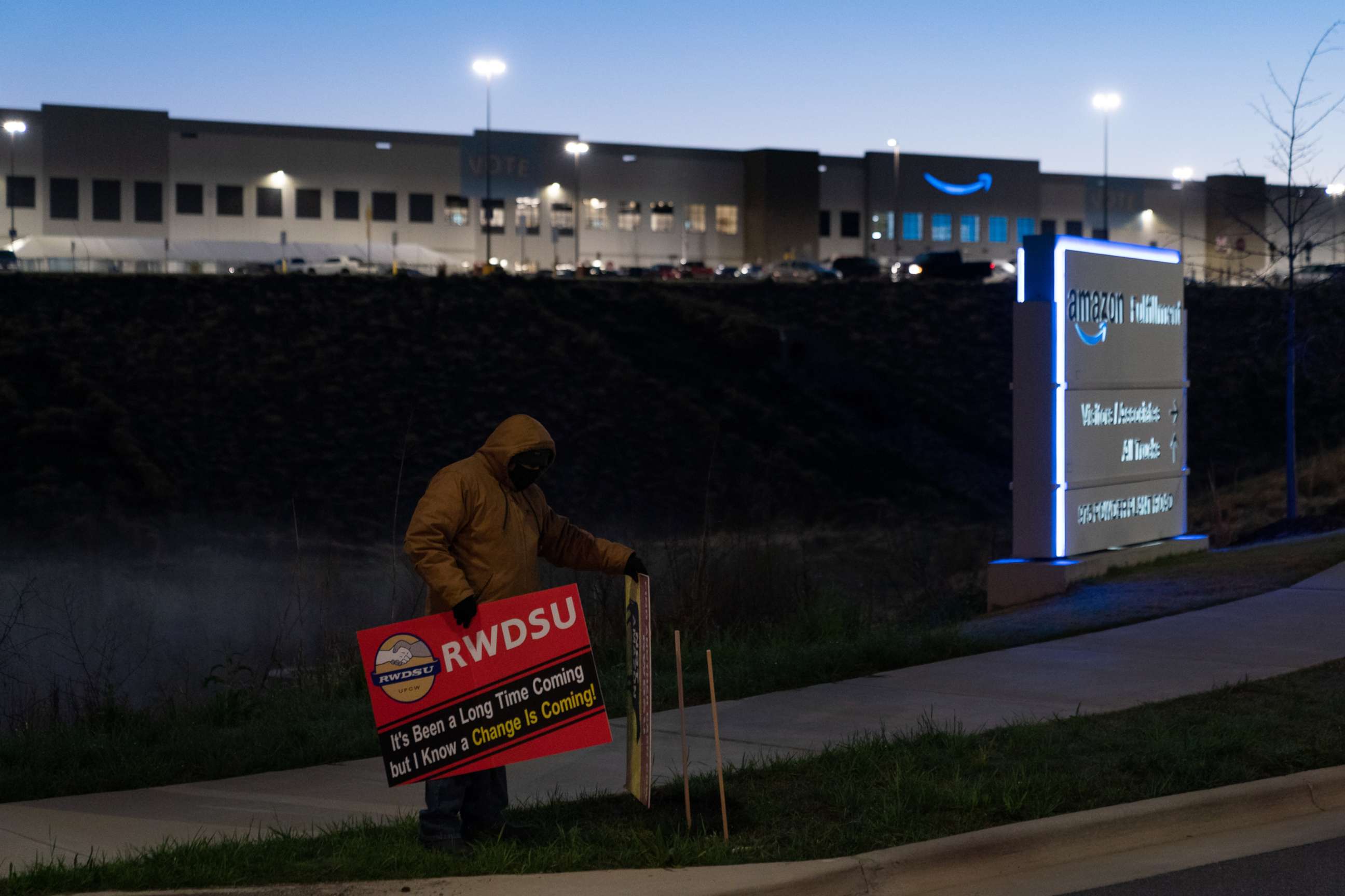 PHOTO: An RWDSU union rep holds a sign outside the Amazon fulfillment warehouse at the center of a unionization drive, March 29, 2021. in Bessemer, Ala.