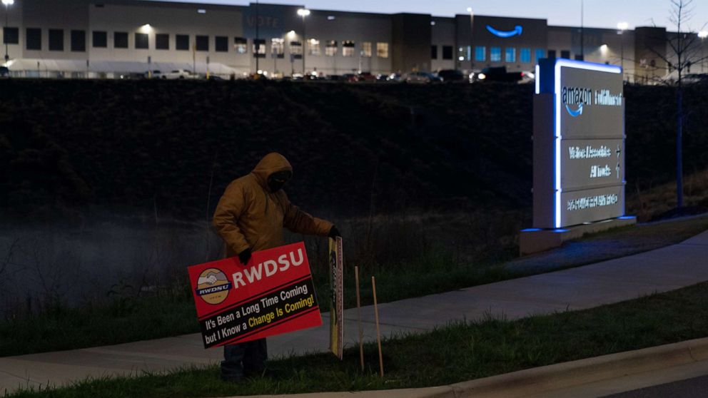 PHOTO: An RWDSU union rep holds a sign outside the Amazon fulfillment warehouse at the center of a unionization drive, March 29, 2021. in Bessemer, Ala.