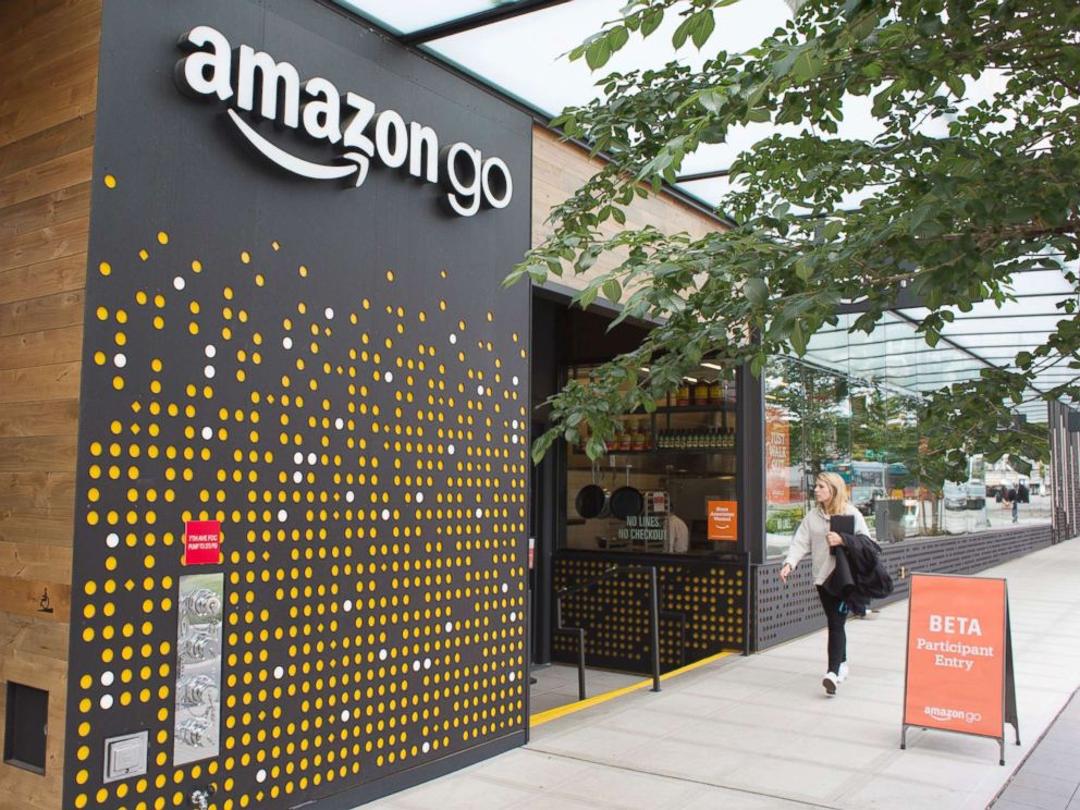 PHOTO: A woman walks past the Amazon Go grocery store at the Amazon corporate headquarters on June 16, 2017, in Seattle.