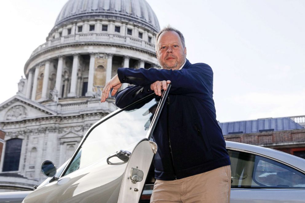 PHOTO: Andy Palmer, chief executive officer of Aston Martin Lagonda Global Holdings Plc, poses for a photograph with an Aston Martin DB5 automobile outside the London Stock Exchange in London, Oct. 3, 2018.