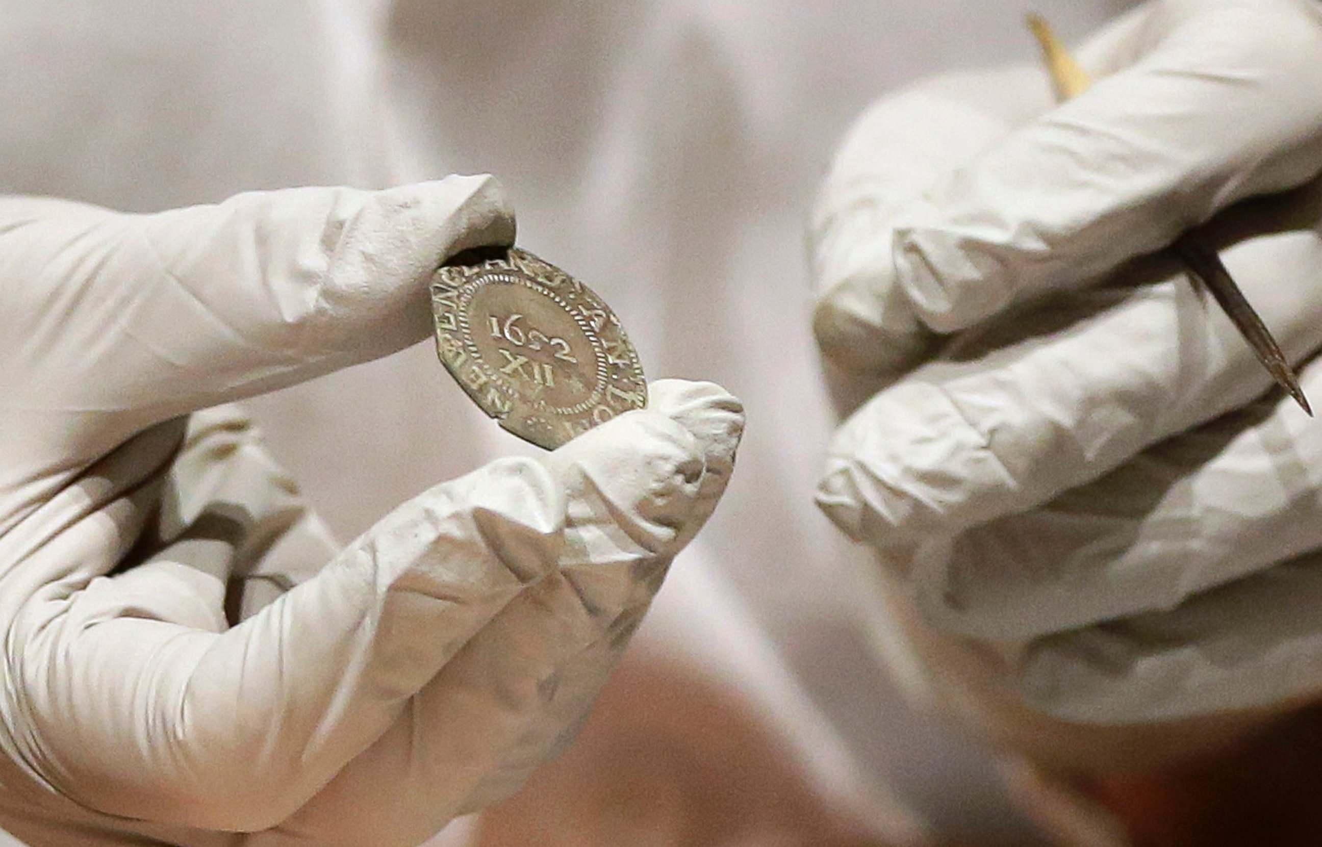 PHOTO: Museum of Fine Arts Boston Head of Objects Conservation Pam Hatchfield displays a coin as she removes it from a time capsule at the museum, Jan. 6, 2015, in Boston.