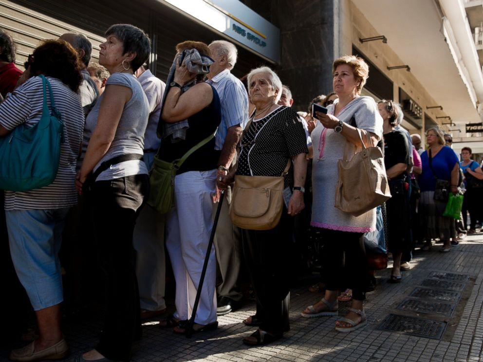 PHOTO: Pensioners line up as the wait to be allowed into a bank in Athens, July 1, 2015 , and withdraw a maximum 120 euros for the week, during capital controls in Greece.