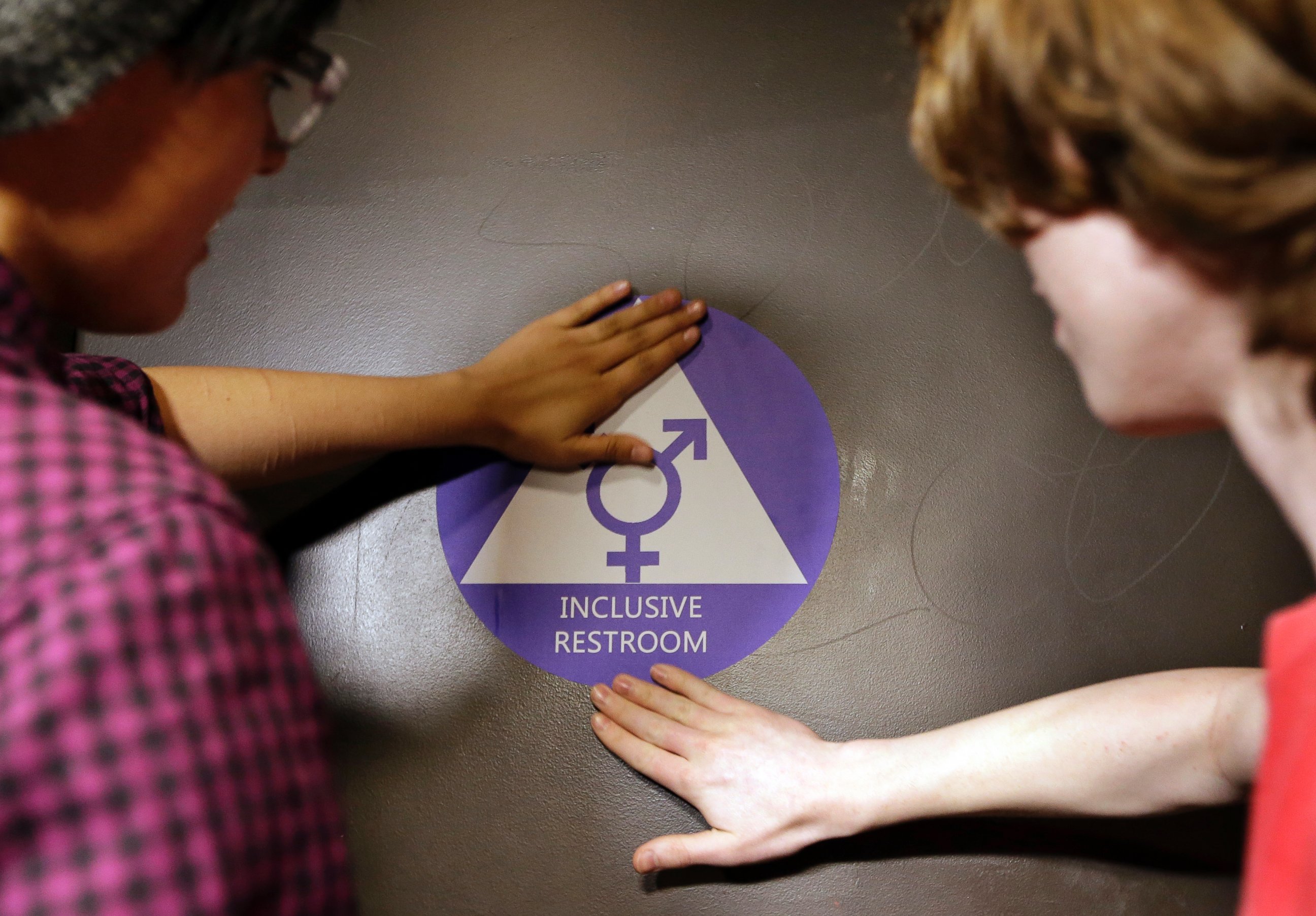 PHOTO: People place a sticker on the door at the ceremonial opening of a gender neutral bathroom at Nathan Hale high school, May 17, 2016, in Seattle.