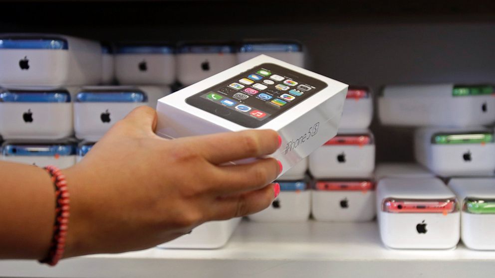 A sales person pulls out an iPhone 5s for a customer during the opening day of sales of the iPhone 5s and iPhone 5C, Sept. 20, 2013, in Hialeah, Fla.