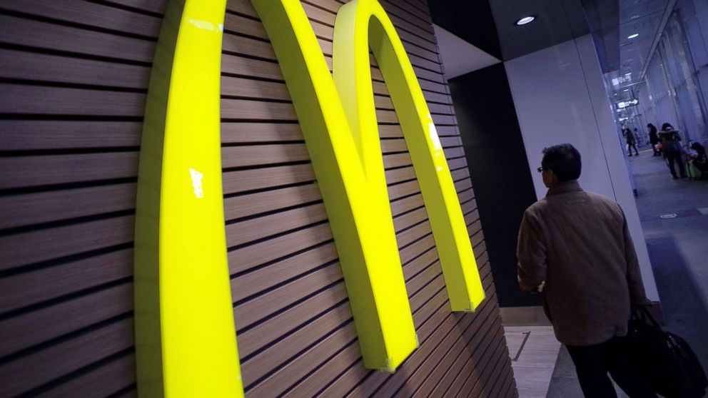 In this Dec. 17, 2014 file photo, a man walks by a logo of McDonald's in front of its restaurant in Tokyo.
