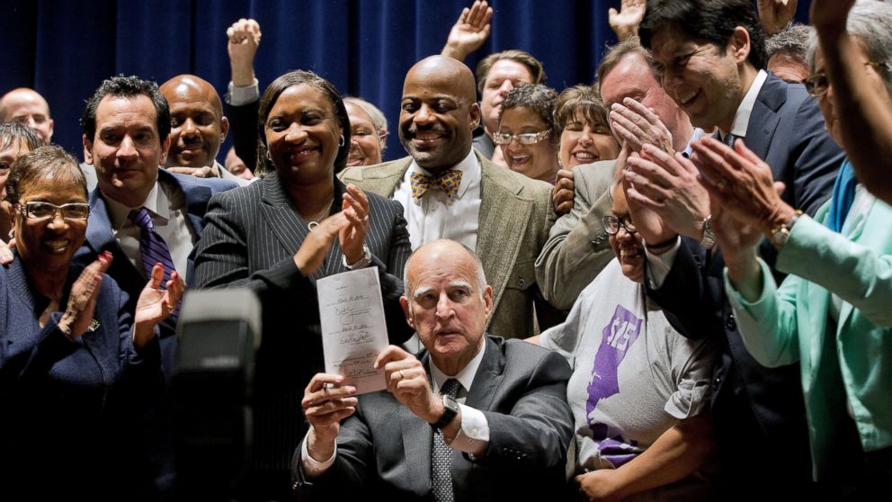 California Gov. Jerry Brown holds a signed bill creating the highest statewide minimum wage at $15 an hour by 2022 at the Ronald Reagan building in Los Angeles, April 4, 2016.