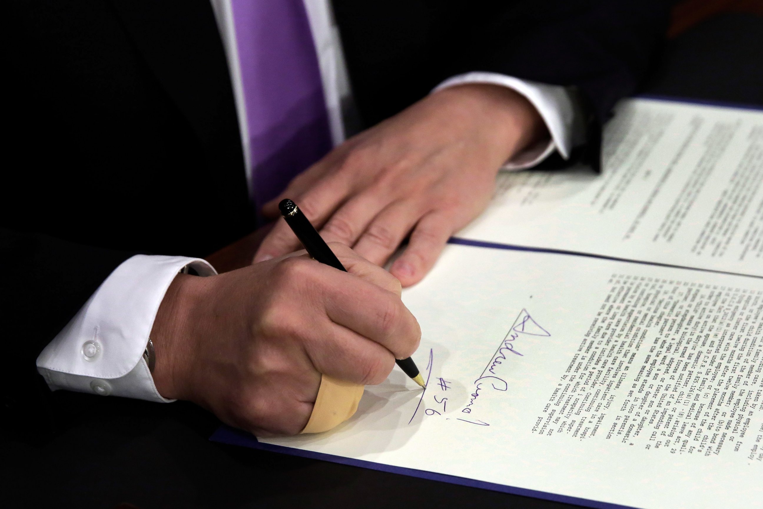 PHOTO: New York Gov. Andrew Cuomo, signs a law that will gradually raise New York's minimum wage to $15, at the Javits Convention Center, in New York, April 4, 2016.