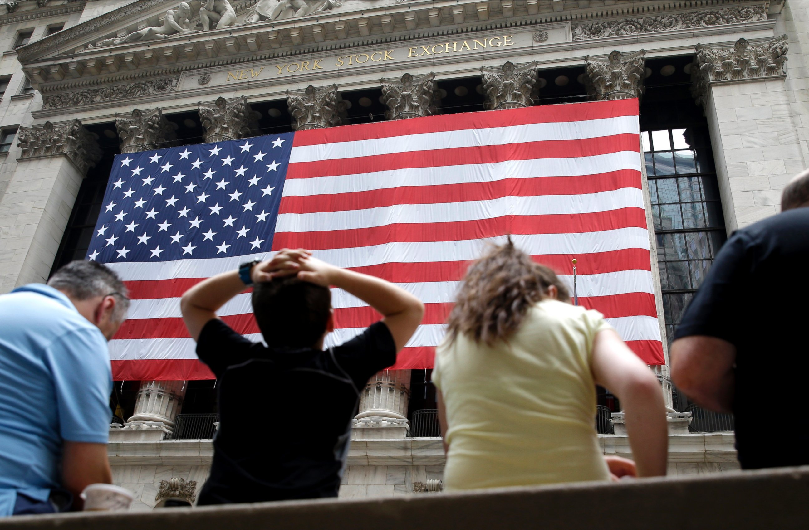 PHOTO: People sit on a bench near the New York Stock Exchange, July 8, 2015.