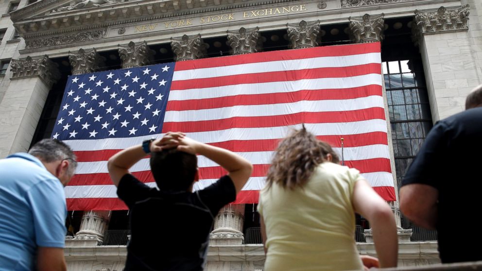PHOTO: People sit on a bench near the New York Stock Exchange, July 8, 2015.