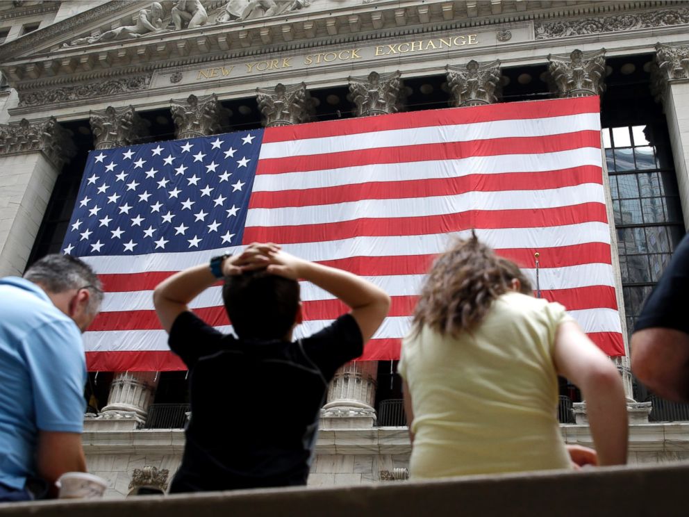 PHOTO: People sit on a bench near the New York Stock Exchange, July 8, 2015.