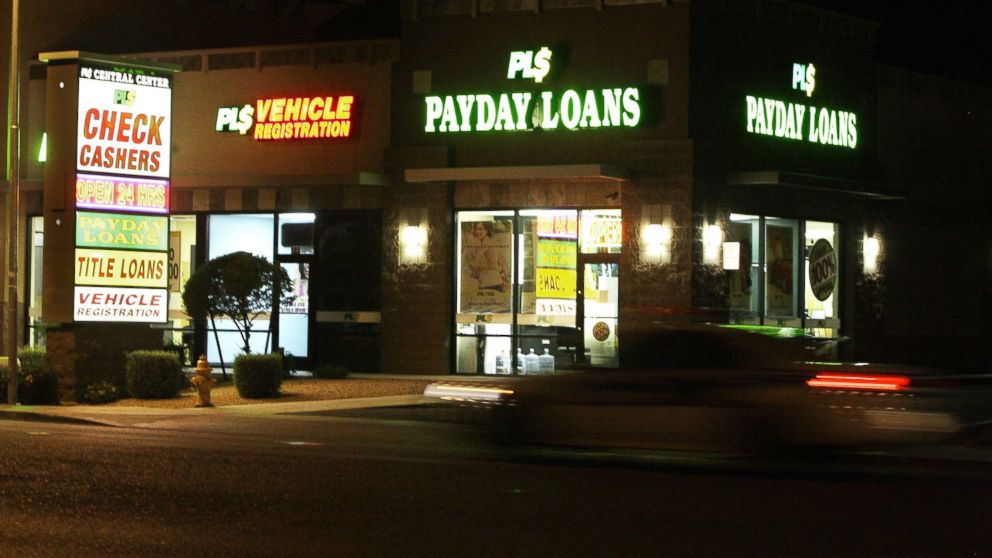 Neon signs illuminate a payday loan business in Phoenix, in this April 6, 2010 photo.