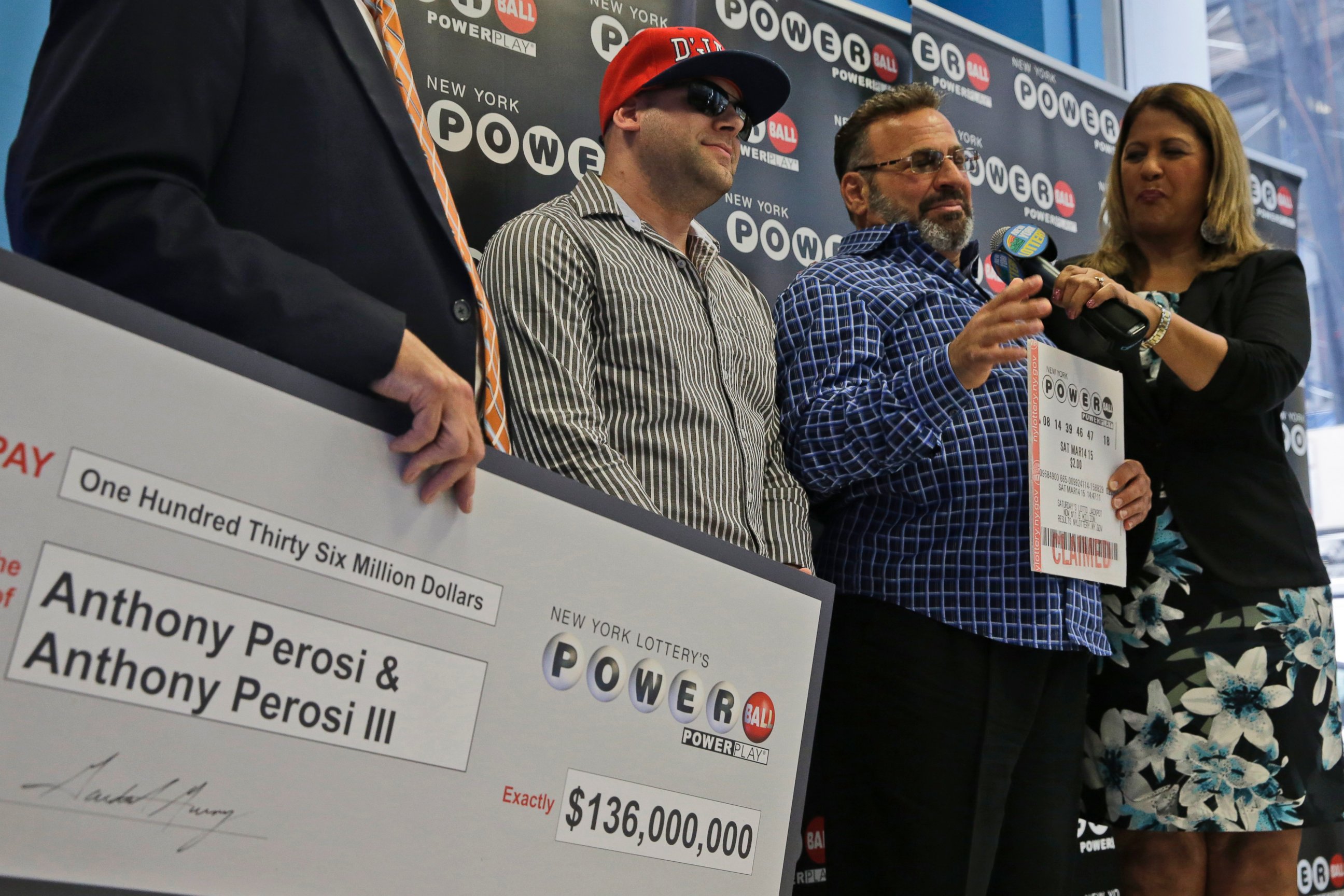 PHOTO: Anthony Perosi, second from right, holding a copy of the winning power ball ticket and his son Anthony Perosi III, second from left, as New York's Lottery Yolanda Vega, right,  presented a prize check, June 4, 2015, in New York.