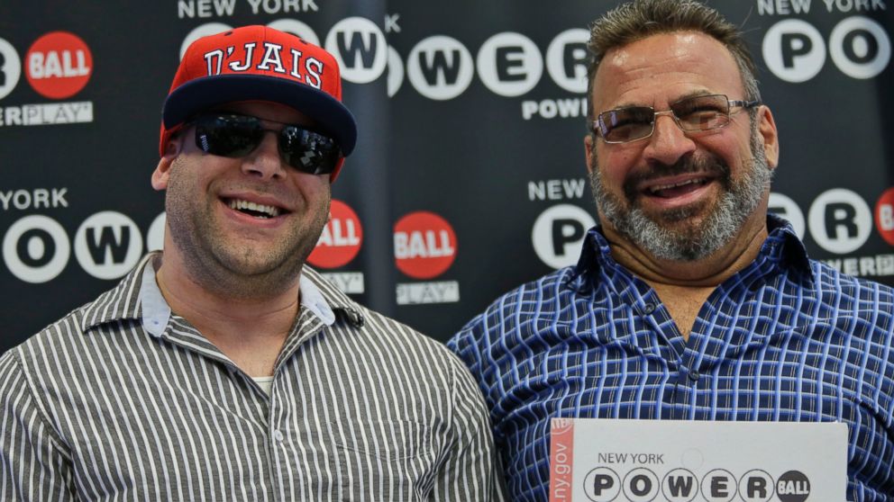 Anthony Perosi, right, holding a copy of the winning power ball ticket and his son Anthony Perosi III during a ceremony where they were presented an over-sized $136,000,000 prize check, June 4, 2015, in New York. 