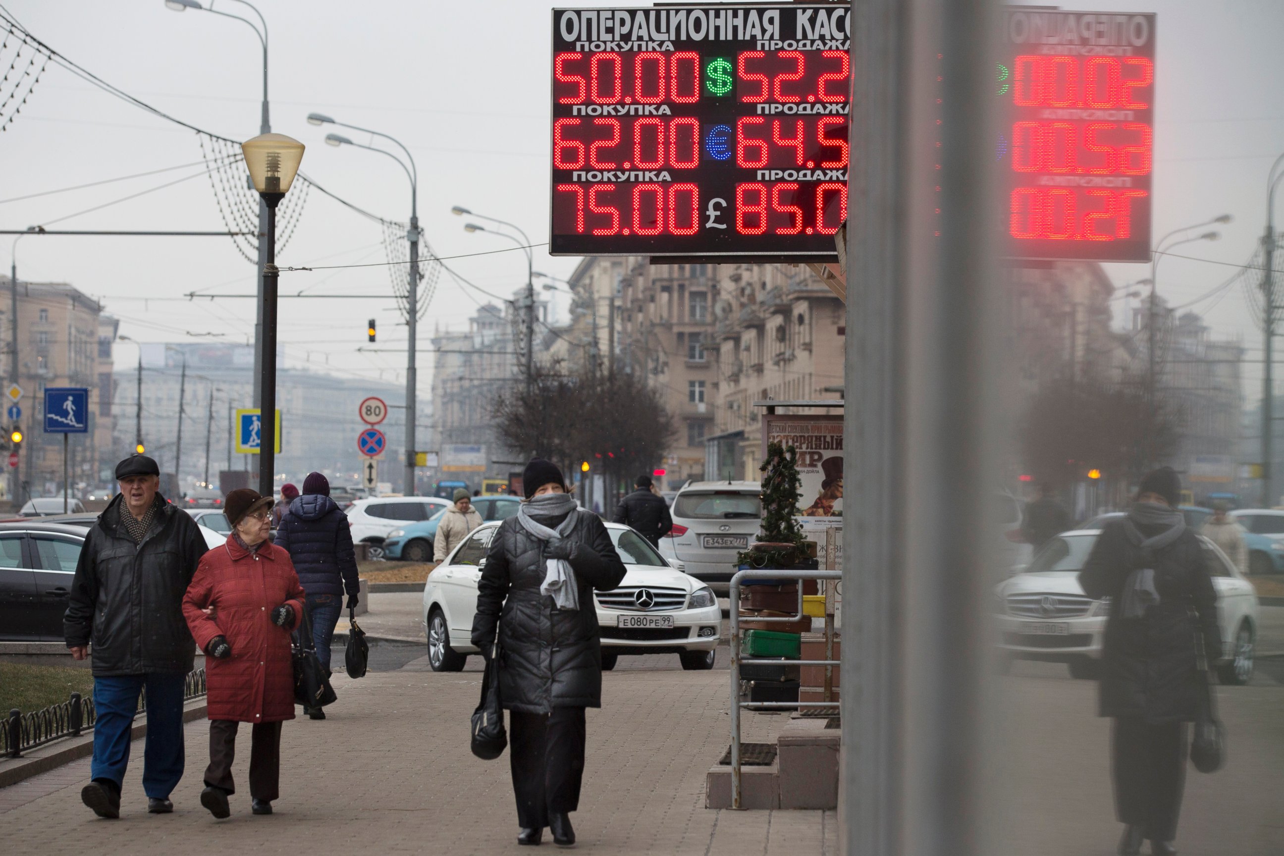 PHOTO: People walk past a display with currency exchange rates in central Moscow, Dec. 1, 2014. 