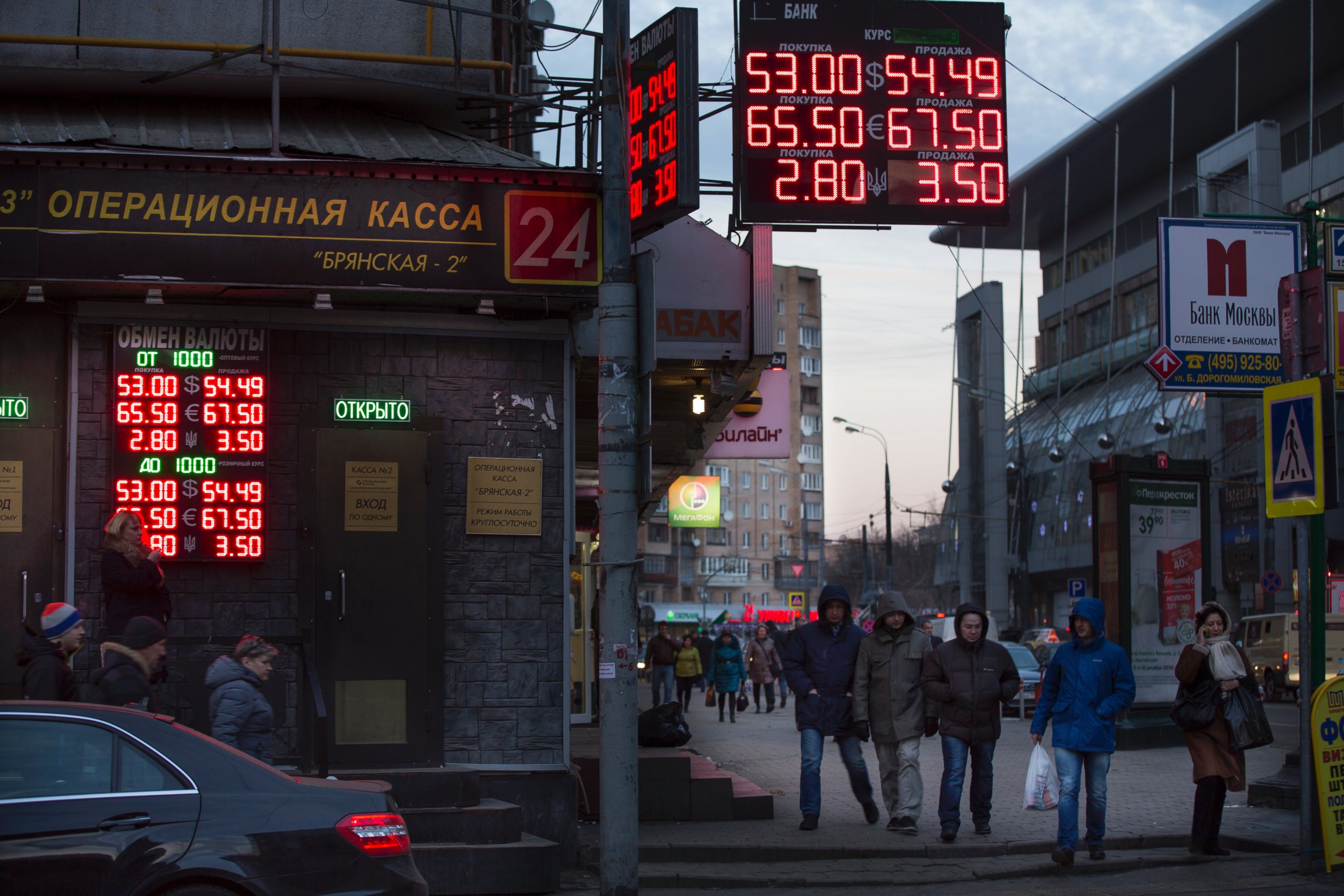 PHOTO: People walk past a display with various currency exchange rates at Kievskaya (Kiev's) railway station in Moscow, Dec. 3, 2014. 