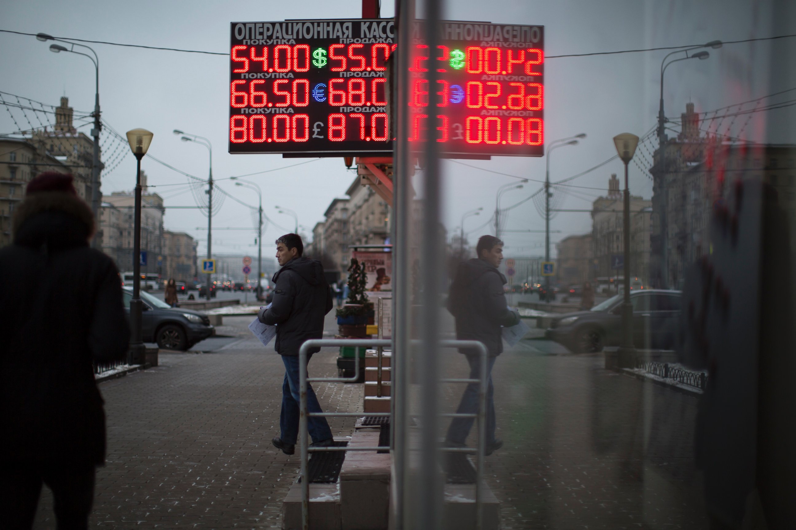 PHOTO: People walk past a display with currency exchange rates in Moscow, Dec. 9, 2014.