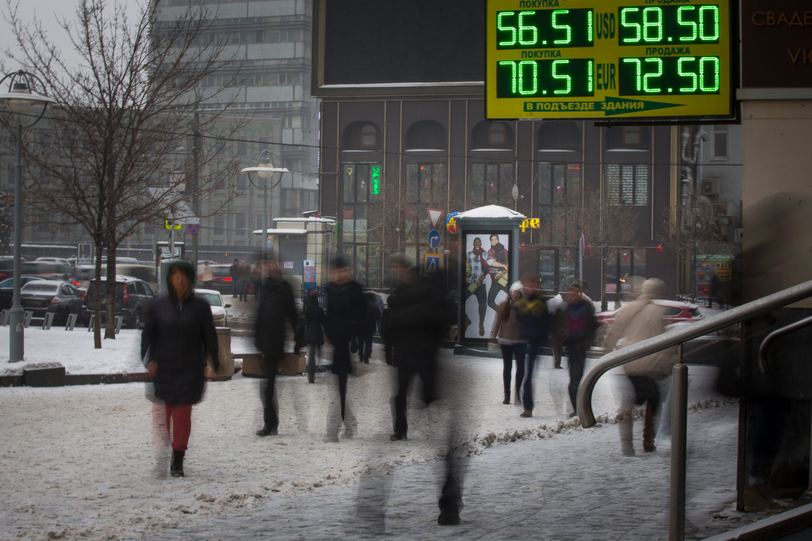 PHOTO: People walk past a sign advertising currency exchange rates in Moscow, Dec. 12, 2014. 