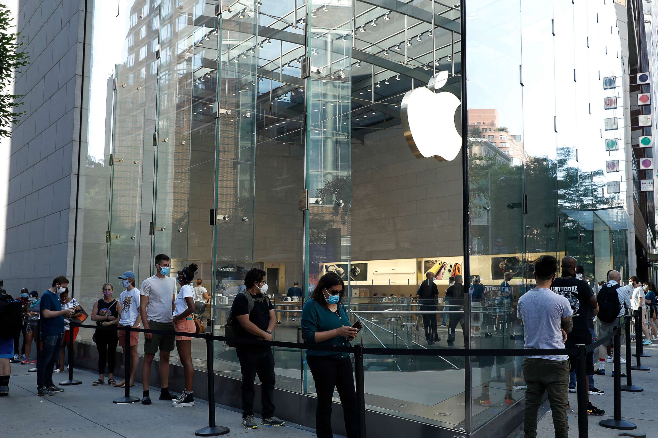 PHOTO: In this June 22, 2020, file photo, customers wait in a queue at an Apple store in New York.