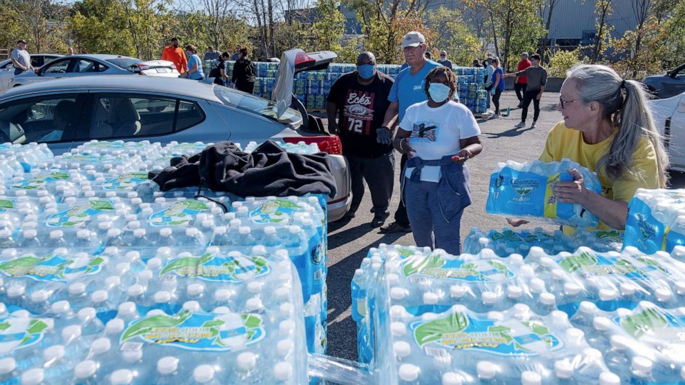 PHOTO: Volunteers with Southwest Community Action Agency load cases of bottled water into residents vehicles, as city officials warn of dangerous amounts of lead in the city's water systems, in Benton Harbor, Mich., Oct. 20, 2021.
