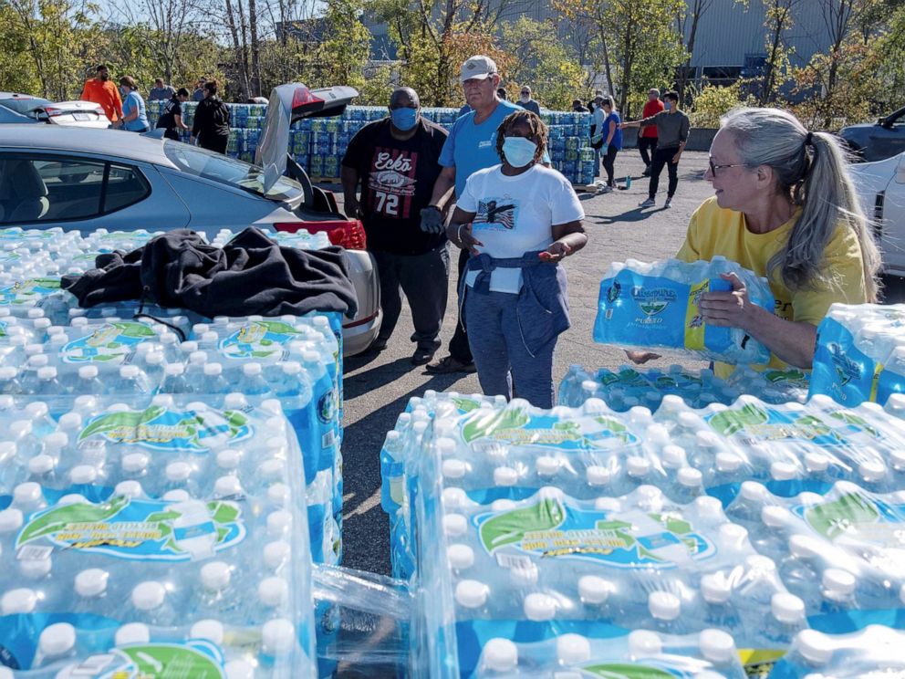 PHOTO: Volunteers with Southwest Community Action Agency load cases of bottled water into residents vehicles, as city officials warn of dangerous amounts of lead in the city's water systems, in Benton Harbor, Mich., Oct. 20, 2021.