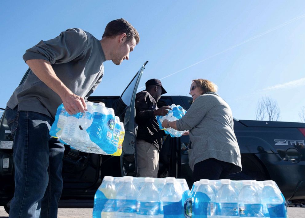 PHOTO: Volunteers with Southwest Community Action Agency load cases of bottled water into residents vehicles, as city officials warn of dangerous amounts of lead in the city's water systems, in Benton Harbor, Mich., Oct. 20, 2021.