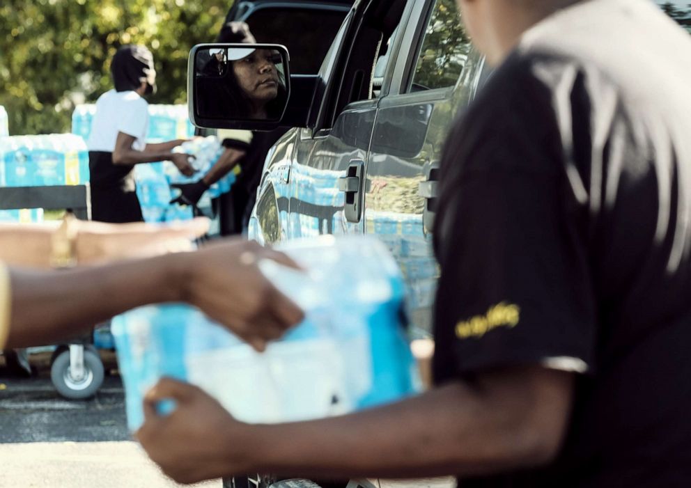 PHOTO: Volunteers distribute bottled water to residents at the Abundant Life Church of God in Benton Harbor, Michigan, Oct. 19, 2021.