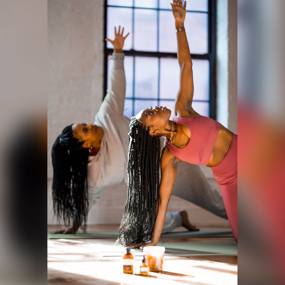 PHOTO: BK Yoga Club owners, Paris Alexandra and Alicia Ferguson get on the mat during yoga session.