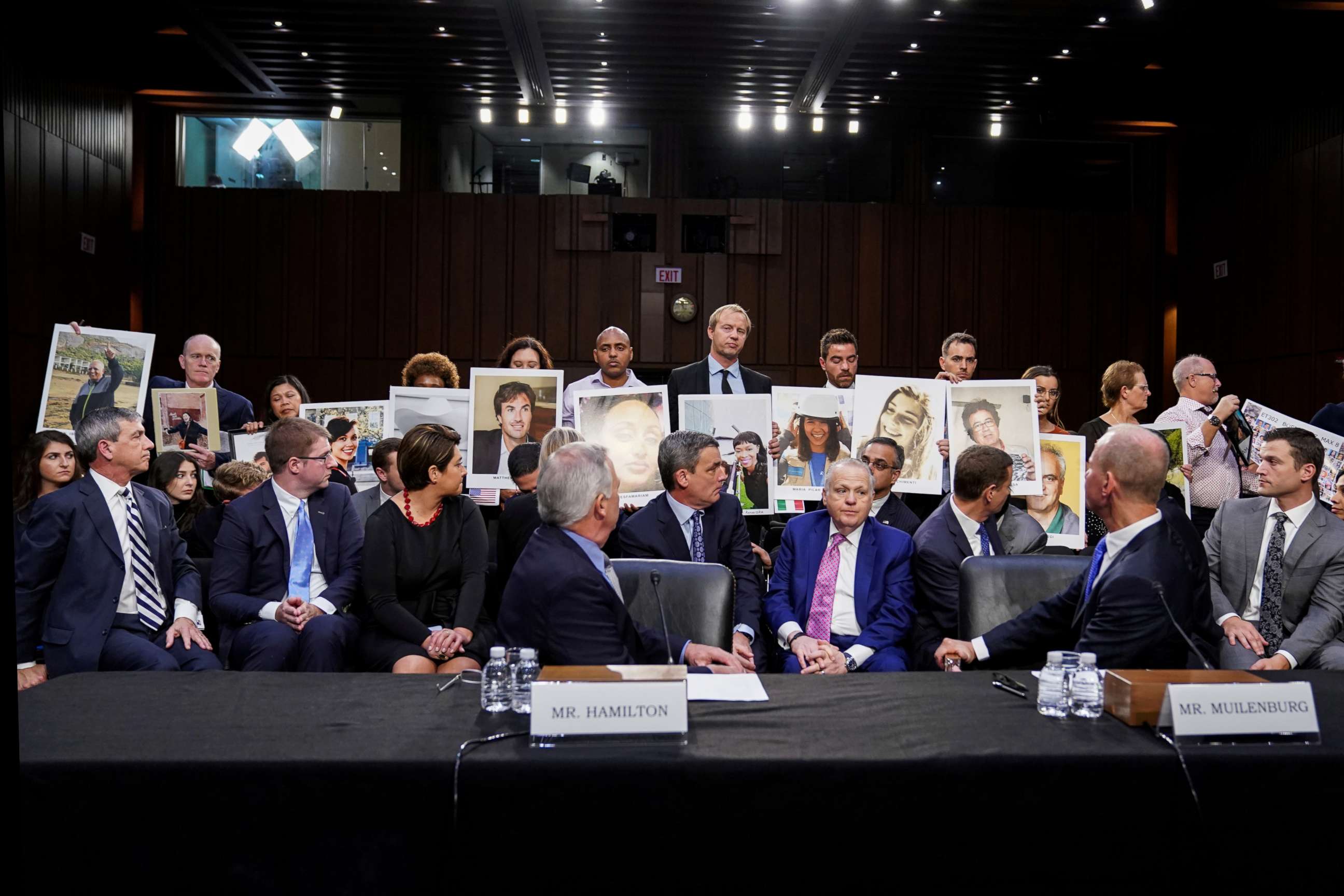 PHOTO: Boeing's Vice President and Chief Engineer John Hamilton, and Chief Executive Dennis Muilenburg, look at family members holding photos of 737 Max crash victims during a hearing on aviation safety on Capitol Hill, Oct. 29, 2019, in Washington, D.C.