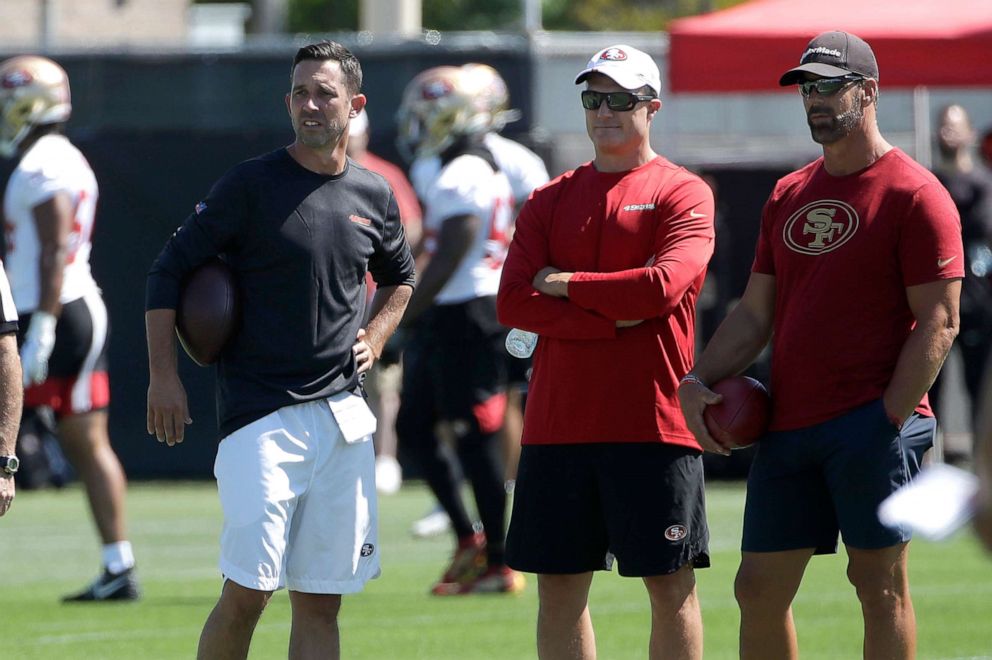 PHOTO: San Francisco 49ers head coach Kyle Shanahan, from left, watches as players practice with general manager John Lynch and broadcaster Tim Ryan at the team's NFL football training camp in Santa Clara, Calif., July 27, 2019.