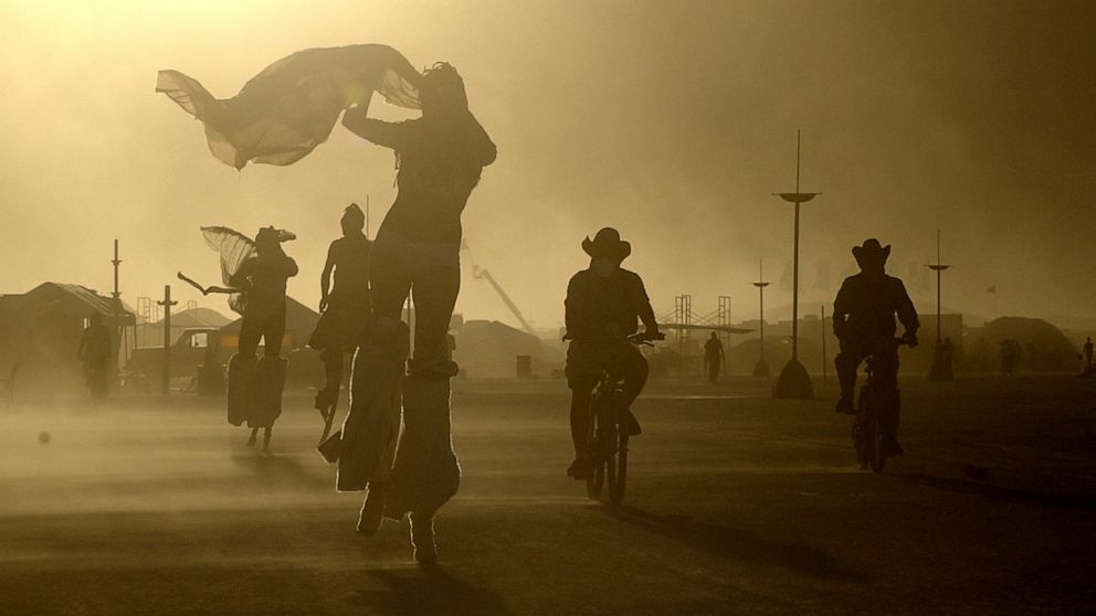 PHOTO: A windstorm whips sand at Burning Man as participants take evening bike rides and strolls on stilts in Black Rock Desert, Nev., Aug. 8, 2005.