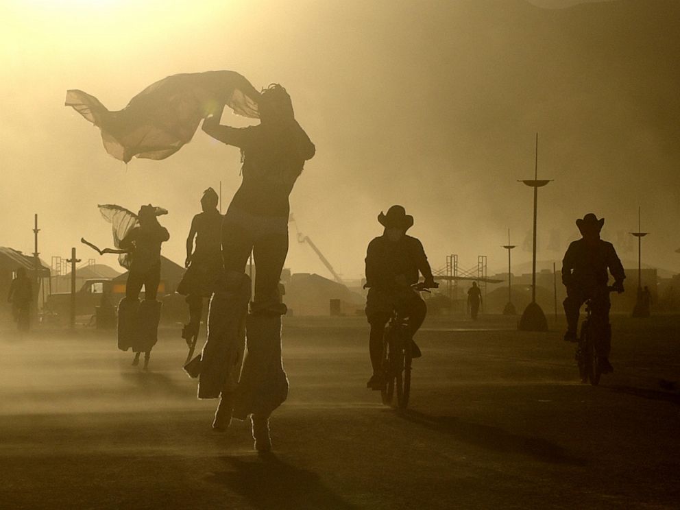 PHOTO: A windstorm whips sand at Burning Man as participants take evening bike rides and strolls on stilts in Black Rock Desert, Nev., Aug. 8, 2005.