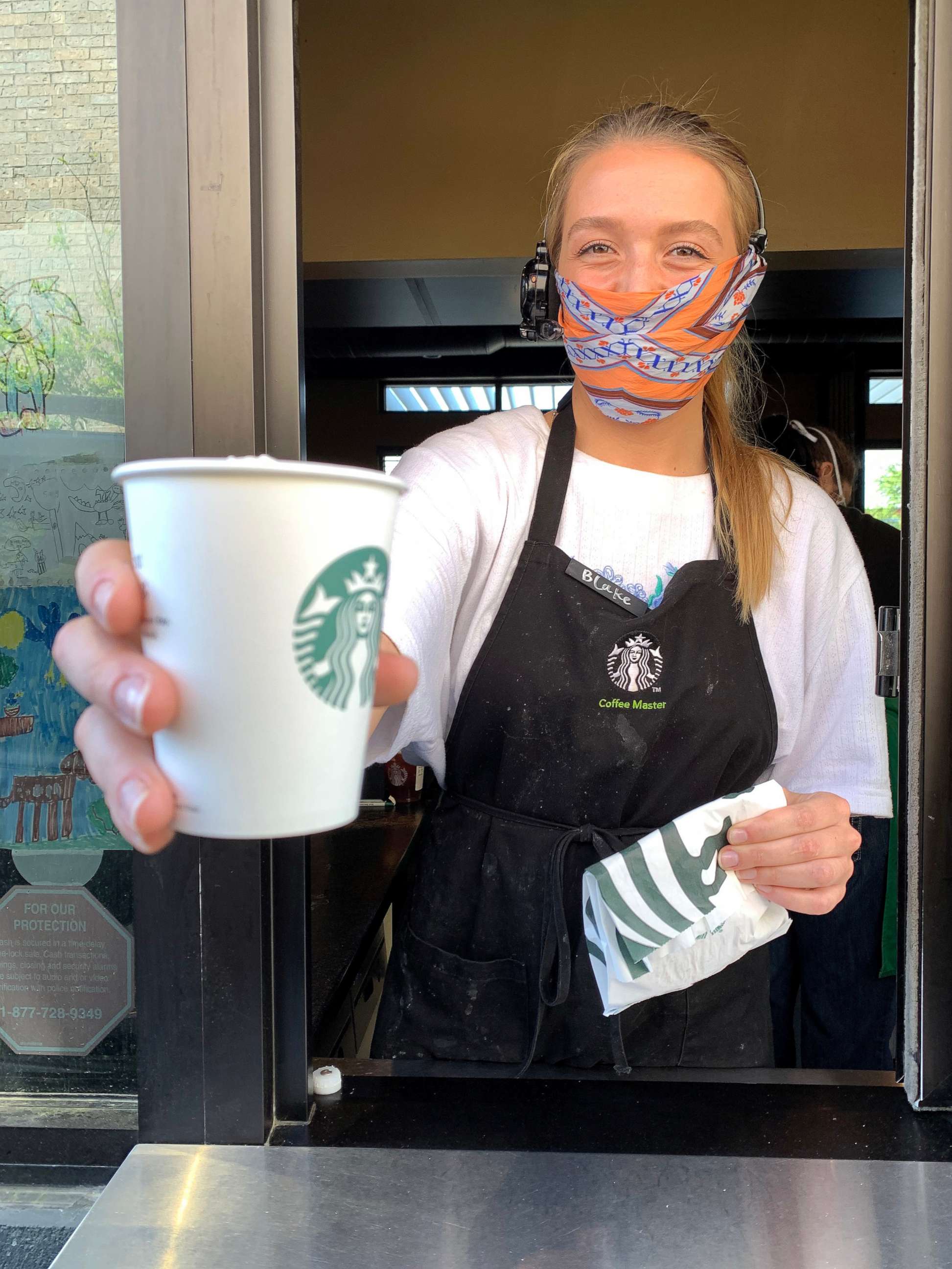 PHOTO: A Starbucks employee wears a facial covering while working the drive-thru during the COVID-19 pandemic on April 07, 2020 in Dallas. 