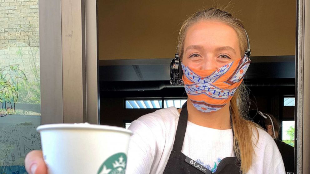 PHOTO: A Starbucks employee wears a facial covering while working the drive-thru during the COVID-19 pandemic on April 07, 2020 in Dallas. 