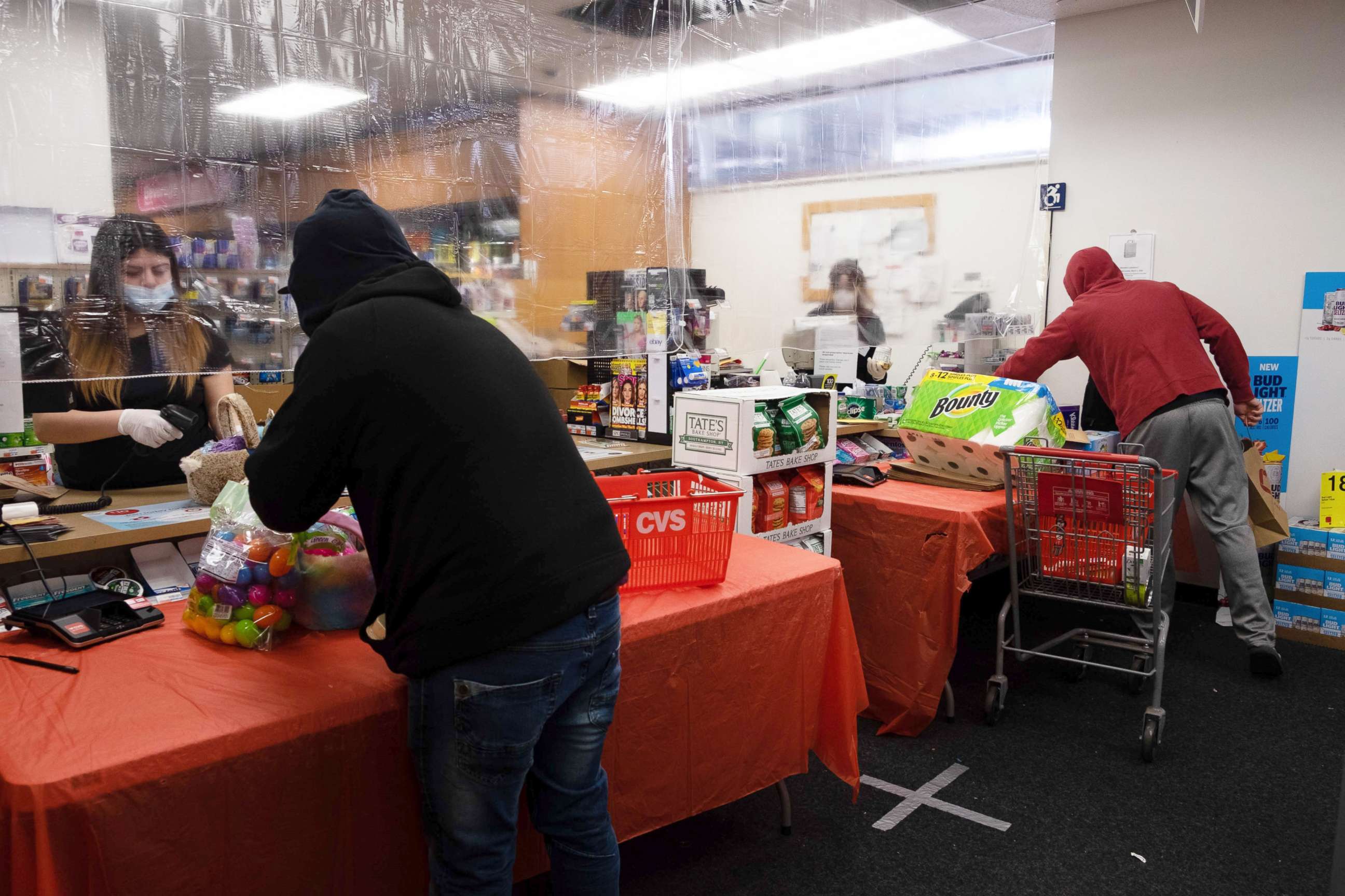 PHOTO: Cashiers at a CVS in Brooklyn are shielded behind a plastic see through curtain as they serve customers, April 9, 2020.
